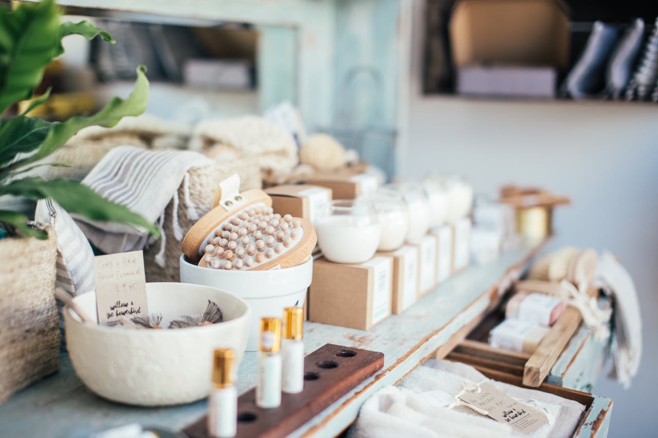 Many fragrant candles placed near massage brushes and perfume in shop for sale